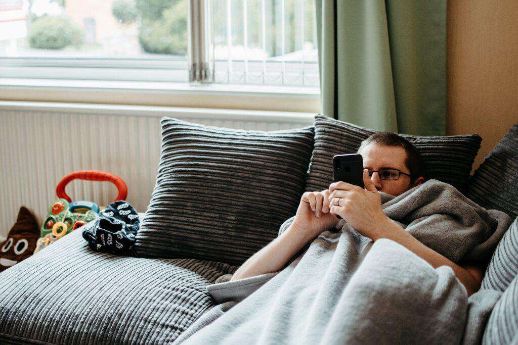 Hombre procastinando en su cama